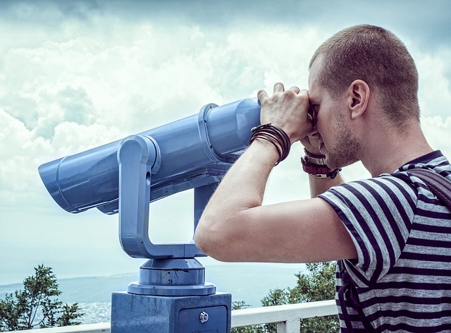A man looking through binoculars to give the idea of looking back at the past year and forwards to the next year