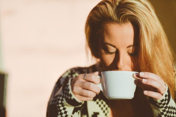 Woman drinking from a cup to show that it is good to finish drinking from a cup so that you can gain and retain the benefits before trying to fit something else in