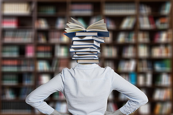 Person with books instead of their head to show how much experience and knowledge is needed to start teaching qigong
