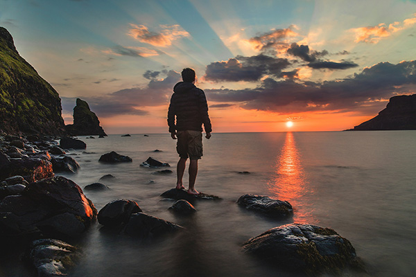 Man gazing to the sunset to show the importance of awareness and presence in qigong and life