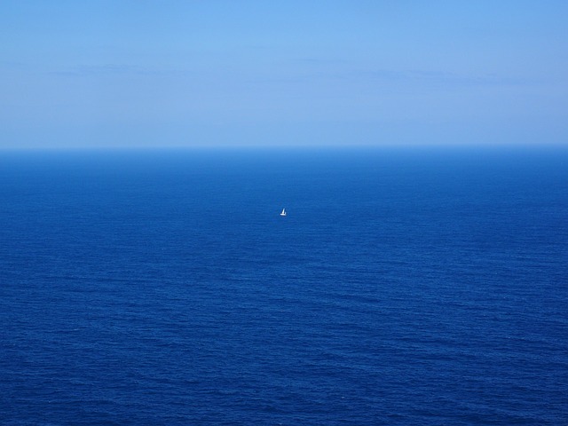 Small boat in the middle of a vast expanse of water to indicate the possibility of being swept away by ocean currents