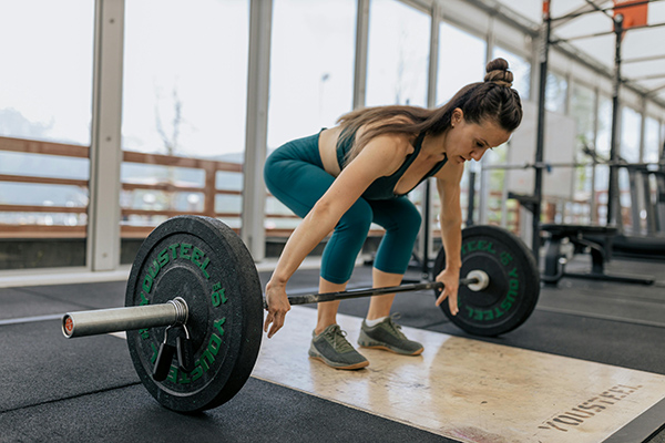 Woman lifting weights to show the importance of the sympathetic nervous system as the accelerator for many of our body's organ's functions