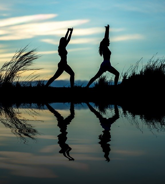 image of two women doing qigong by a lake to give a feeling of the benefits of qigong